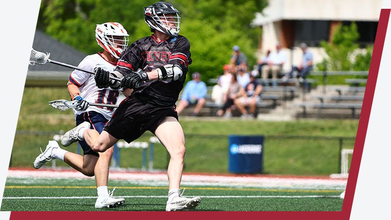 Stevens lacross player runs with the ball up the field.