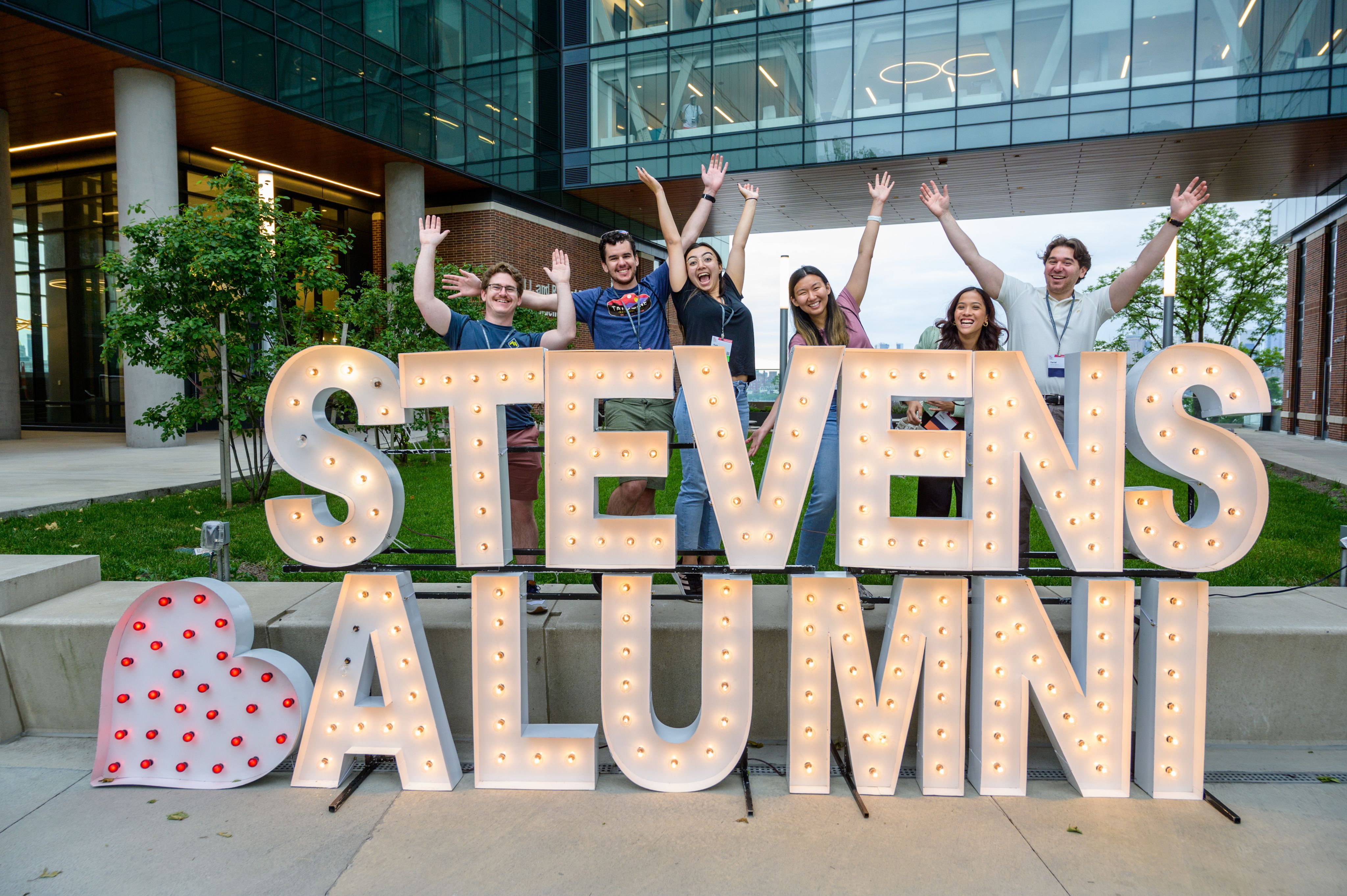 Stevens alumni sign outsite UCC with excited alumni